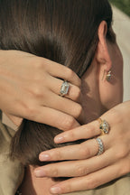 Model wears Perry East-West 5ct emerald solitaire double band engagement ring in 18ct white gold