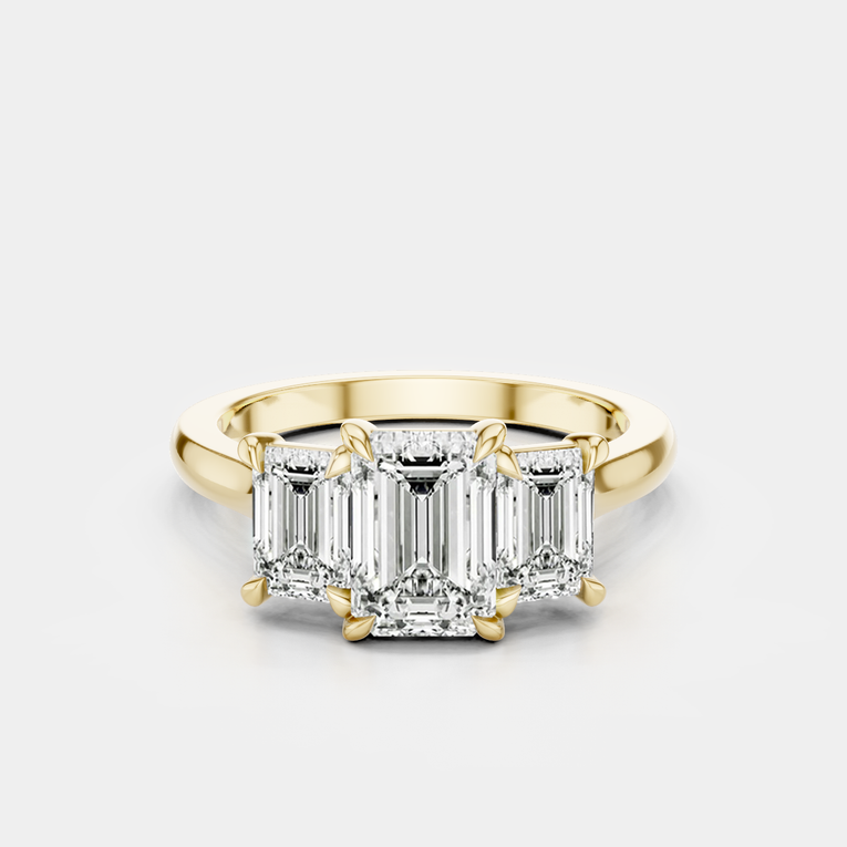 Marion emerald cut trilogy engagement ring in 18ct yellow gold