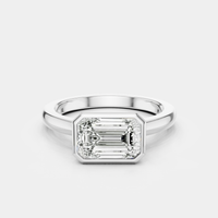 Rowan emerald cut solitaire bezel East-West engagement ring in 18ct white gold