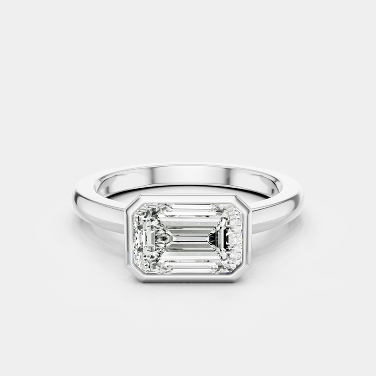 Rowan emerald cut solitaire bezel East-West engagement ring in 18ct white gold