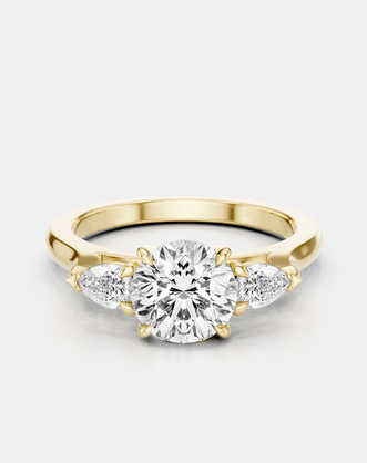 Cornelia round brilliant pear side stone engagement ring in 18ct yellow gold