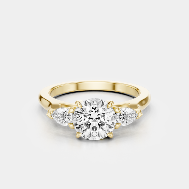 Cornelia round brilliant pear side stone engagement ring in 18ct yellow gold