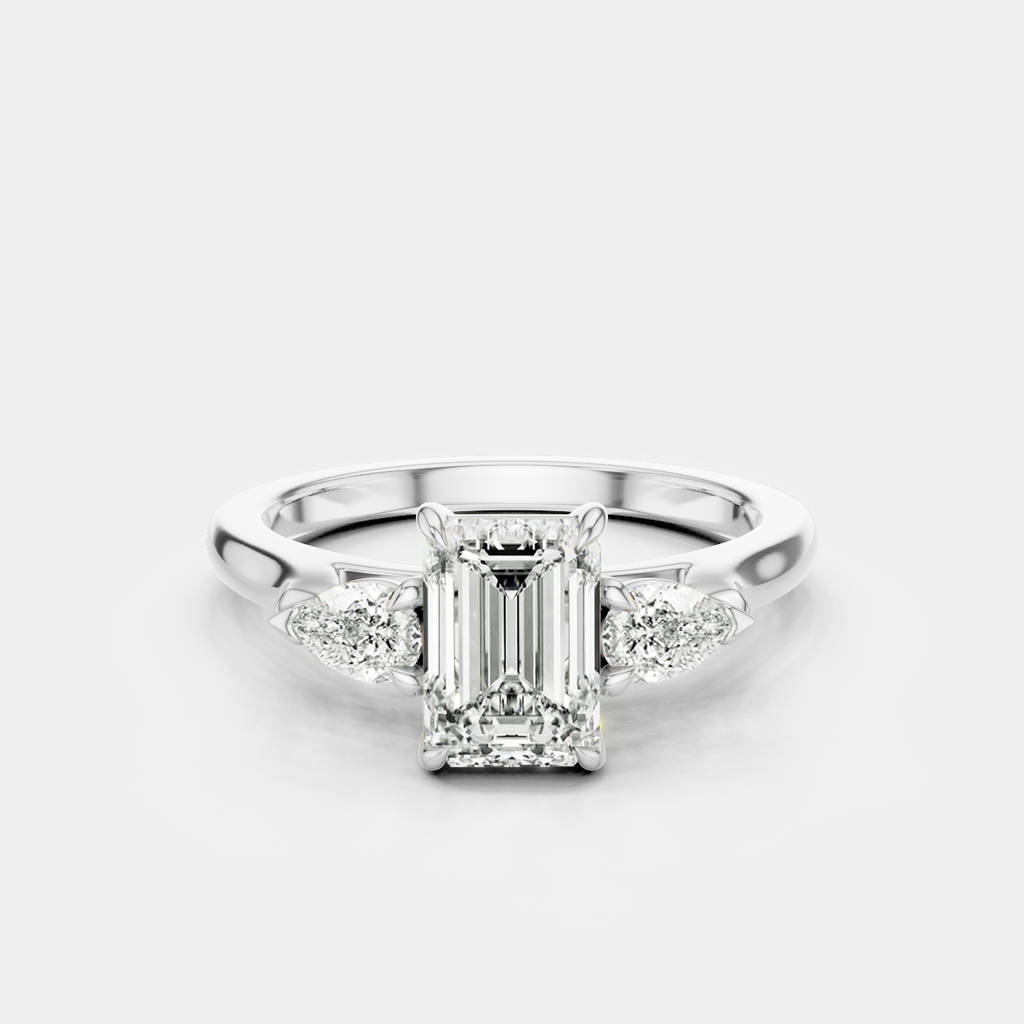 Bruton emerald cut pear side stone engagement ring in 18ct white gold