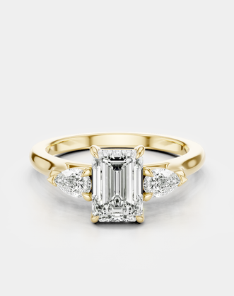 Bruton emerald cut pear side stone engagement ring in 18ct yellow gold