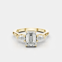 Bruton emerald cut pear side stone engagement ring in 18ct yellow gold
