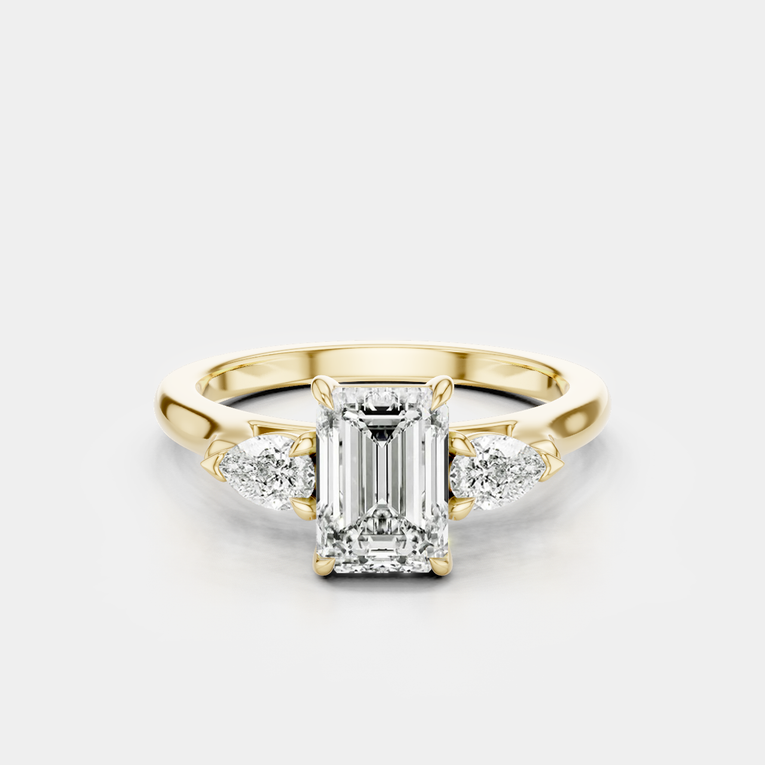 Bruton emerald cut pear side stone engagement ring in 18ct yellow gold
