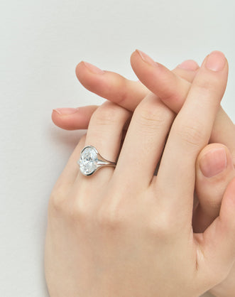 Model wears Bond 4ct oval solitaire semi-bezel engagement ring in 18ct white gold