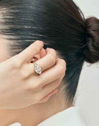 Model wears Mercer East-West 3ct marquise solitaire engagement ring in 18ct yellow gold