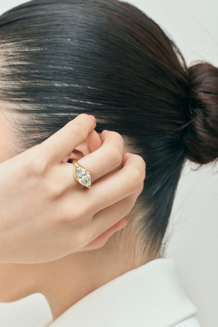 Model wears Mercer East-West 3ct marquise solitaire engagement ring in 18ct yellow gold