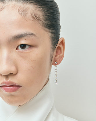 Model wears Noho mixed shape statement drop earrings in 18ct yellow gold 