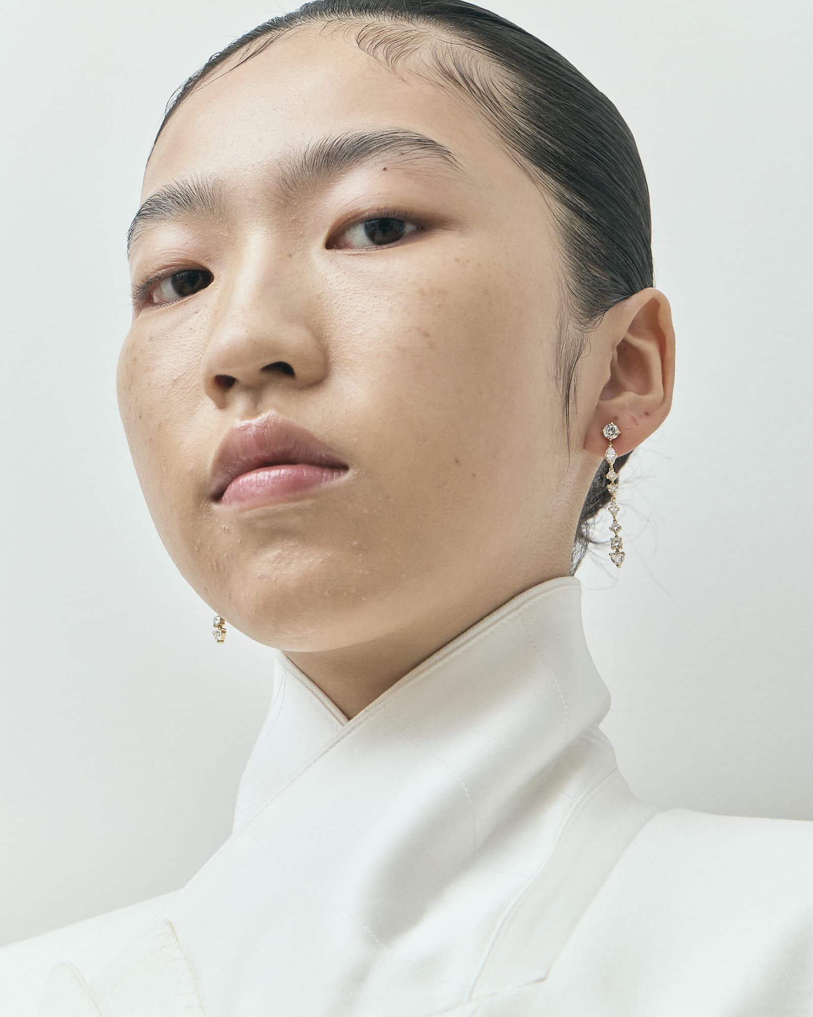 Model wearing LOHR lab-grown diamond earrings in 18ct yellow gold
