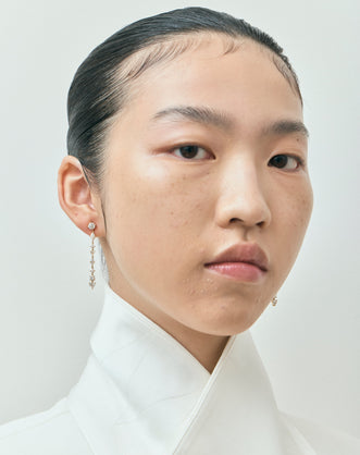 Model wears Noho mixed shape statement drop earrings in 18ct yellow gold 