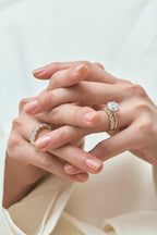 Model wears Cambon round brilliant six claw solitaire swept shoulder engagement ring in 18ct yellow gold