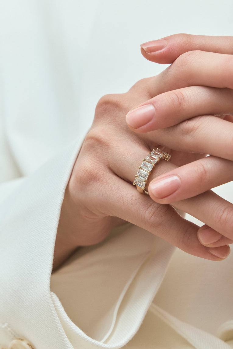 Model wears Soho 0.50ct emerald cut half eternity band in 18ct yellow gold