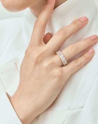 Model wears Soho 0.50ct emerald cut half eternity band in 18ct yellow gold