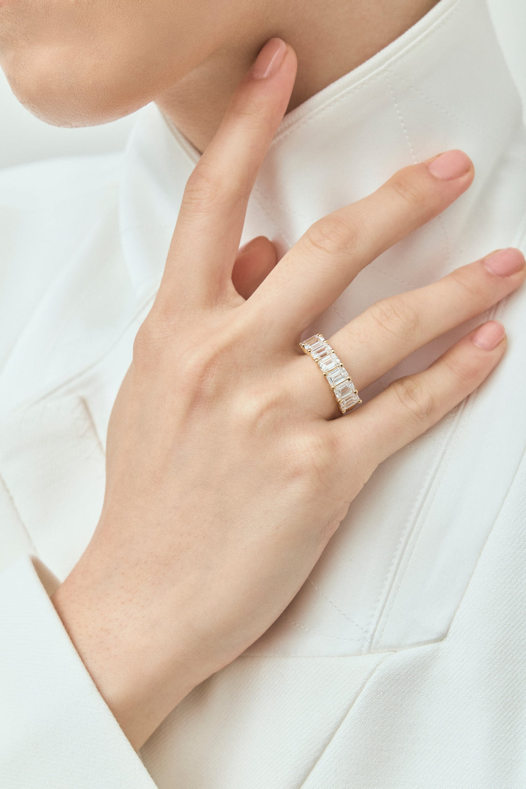 Model wears Soho 0.50ct emerald cut half eternity band in 18ct yellow gold