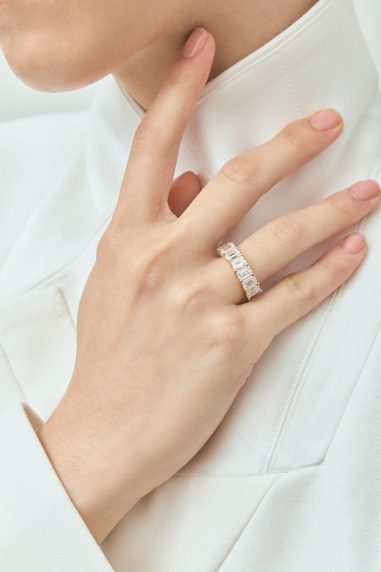 Model wears Soho 0.50ct emerald cut half eternity band in 18ct yellow gold