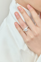 Model wears Cambon round brilliant six claw solitaire swept shoulder engagement ring in 18ct yellow gold