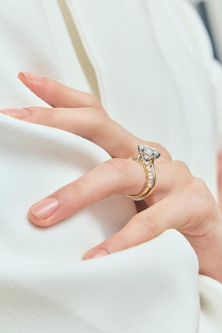 Model wears Cambon round brilliant six claw solitaire swept shoulder engagement ring in 18ct yellow gold