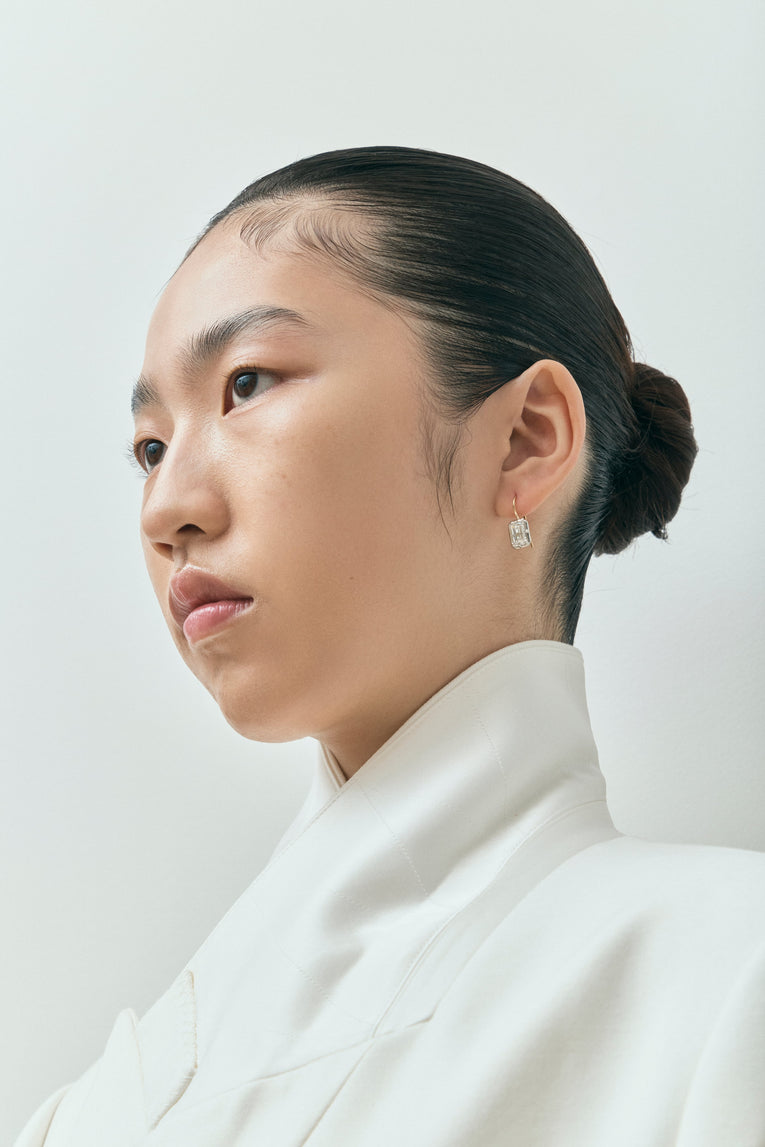 Model wears Avalon 2ct emerald cut button drop earrings in 18ct yellow gold