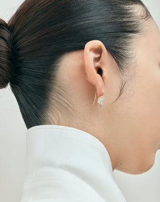 Model wears Avalon 2ct emerald cut button drop earrings in 18ct yellow gold