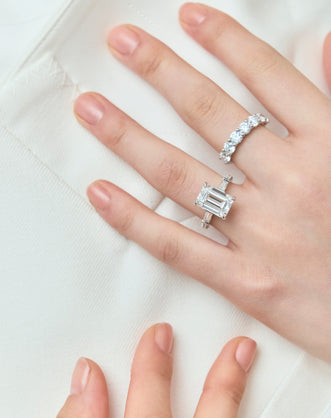 Close-up model wears Cheyne 0.20ct round brilliant half eternity band in 18ct white gold