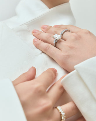Model wears Elizabeth 5ct emerald cut tapered baguette engagement ring in 18ct white gold