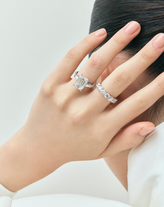 Model wears Elizabeth 5ct emerald cut tapered baguette engagement ring in platinum