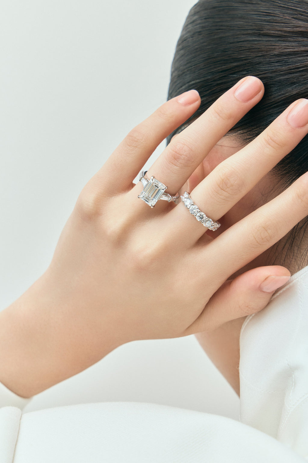 Model wears Elizabeth 5ct emerald cut tapered baguette engagement ring in platinum