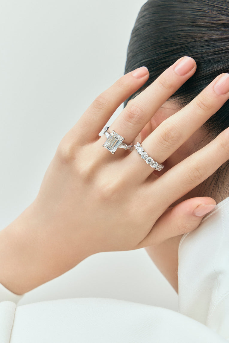 Model wears Elizabeth 5ct emerald cut tapered baguette engagement ring in platinum