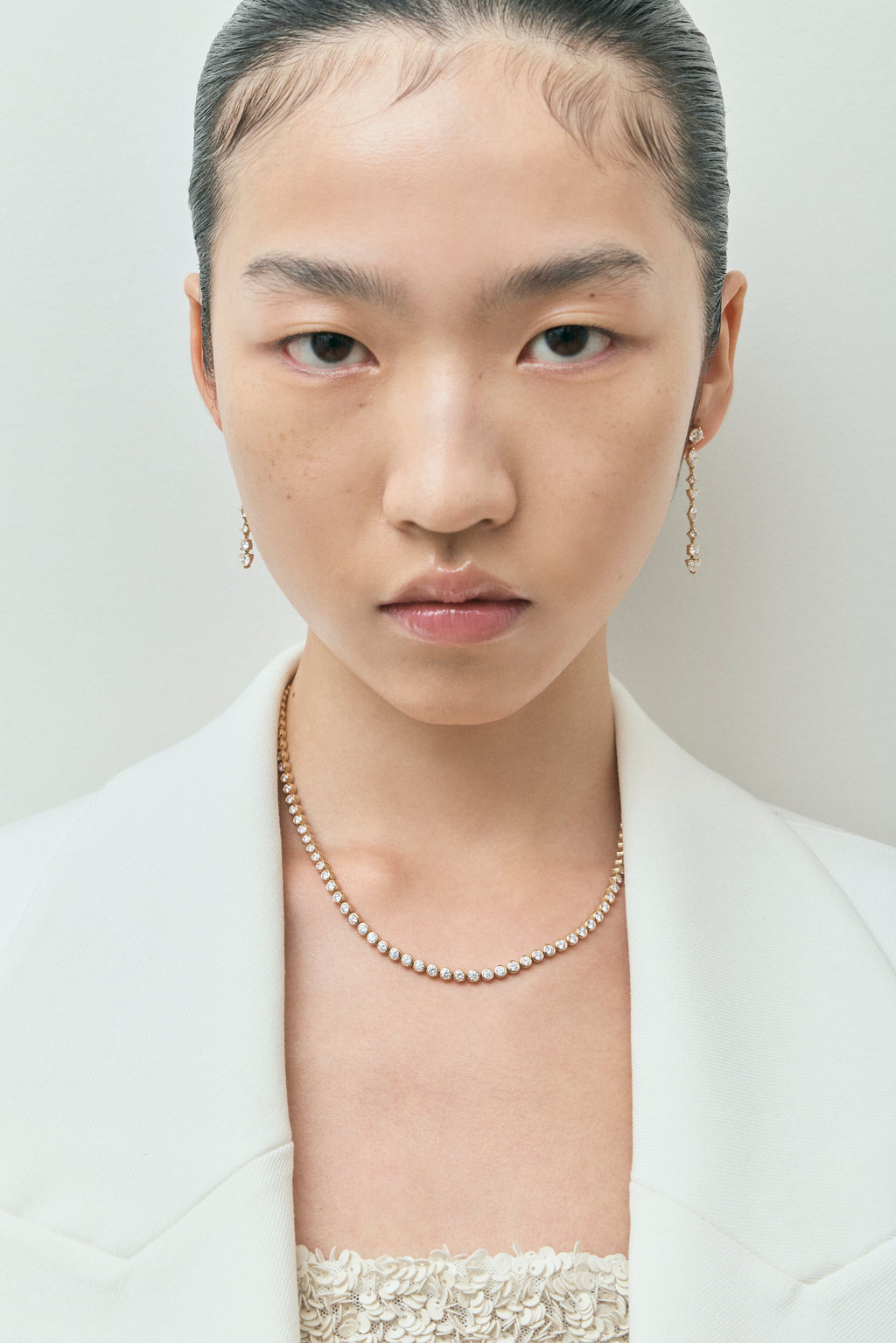 Model wearing York bezel set tennis necklace in 18ct yellow gold