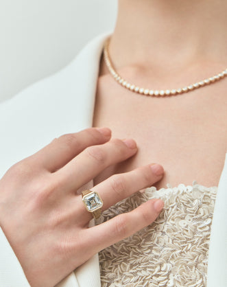 Model wears Rivington 5ct asscher signet bezel grooved band engagement ring in 18ct yellow gold