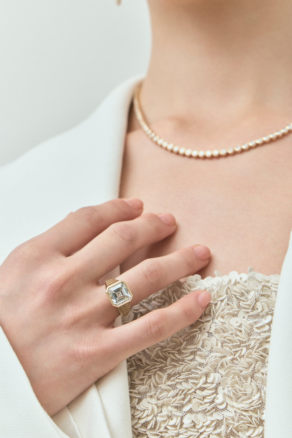 Model wears Rivington 5ct asscher signet bezel grooved band engagement ring in 18ct yellow gold