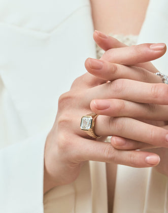 Model wears Rivington 5ct asscher signet bezel grooved band engagement ring in 18ct yellow gold