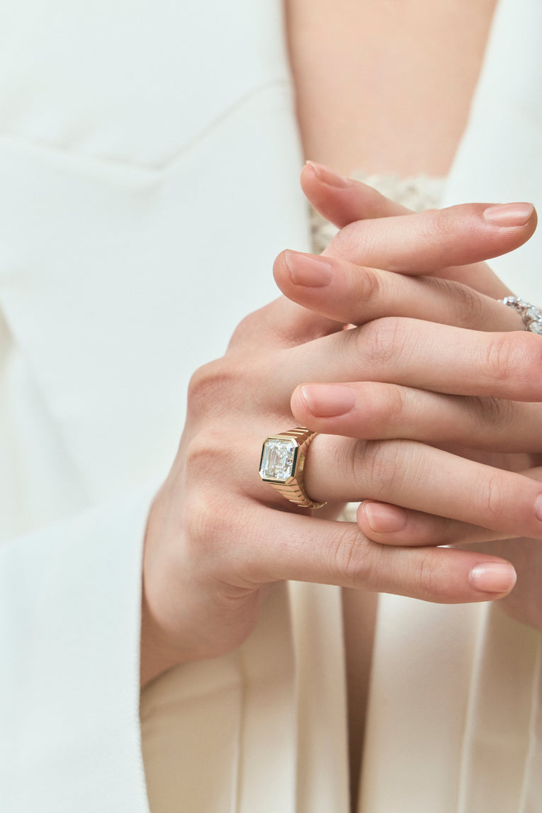 Model wears Rivington 5ct asscher signet bezel grooved band engagement ring in 18ct yellow gold