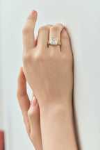 Model wears Rivington 5ct asscher signet bezel grooved band engagement ring in 18ct yellow gold