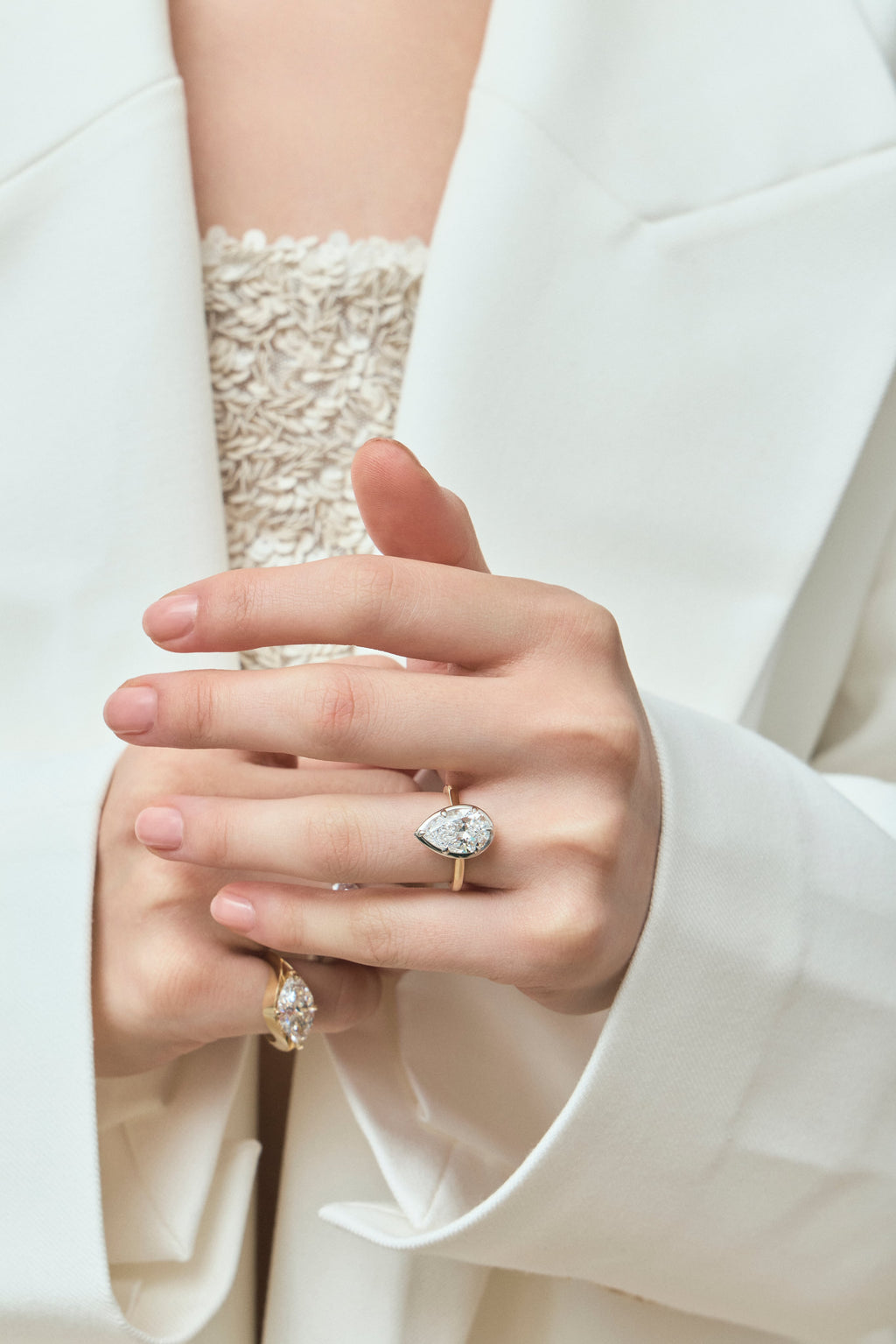Model wears Vestry 3ct pear solitaire scalloped engagement ring in 18ct yellow gold