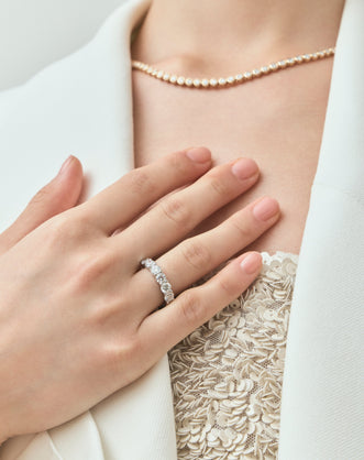 Close-up model wears Cheyne 0.30ct round brilliant half eternity band in 18ct white gold