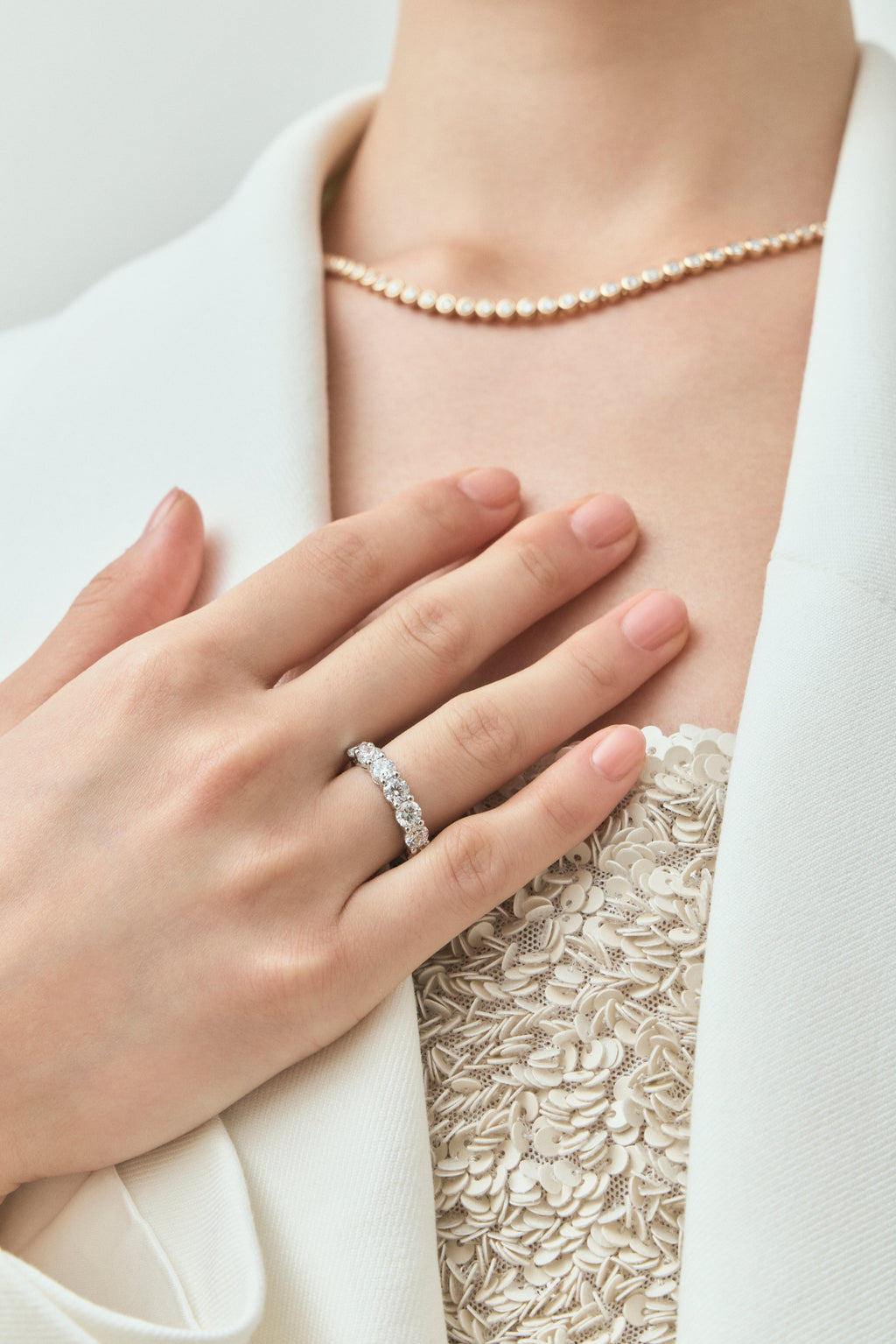 Close-up model wears Cheyne 0.30ct round brilliant half eternity band in 18ct white gold