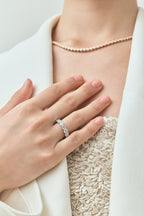 Close-up model wears Cheyne 0.30ct round brilliant half eternity band in 18ct white gold