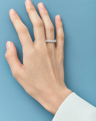 Close-up model wears Cheyne 0.30ct round brilliant half eternity band in platinum