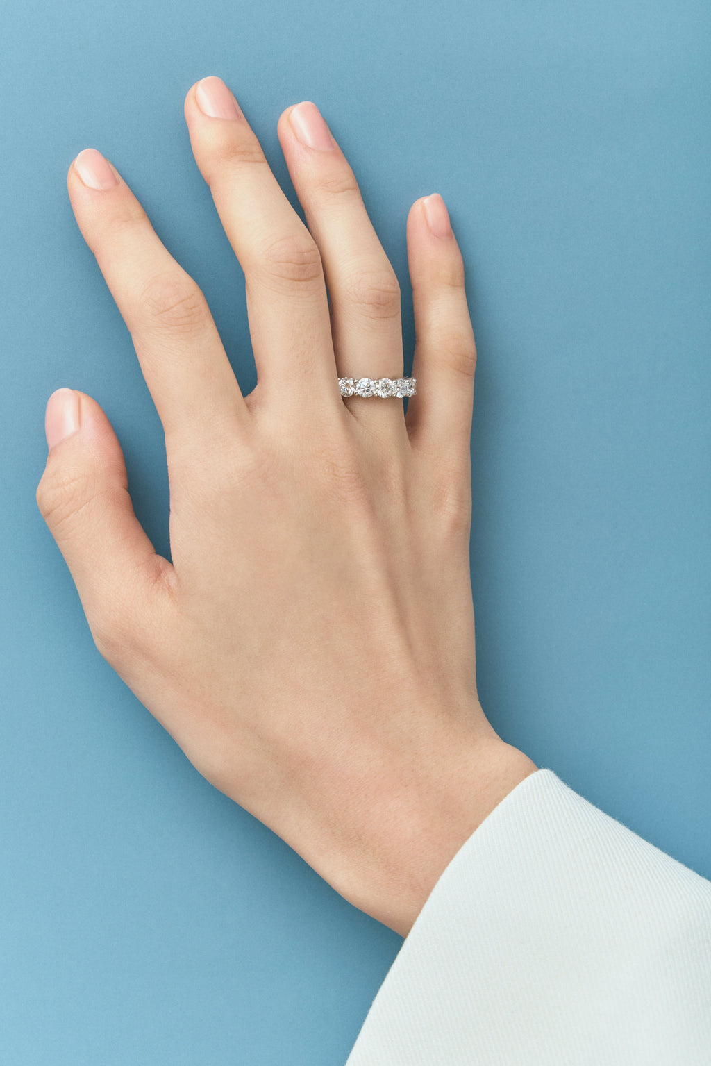 Close-up model wears Cheyne 0.30ct round brilliant half eternity band in platinum