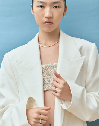 Model wears Dover emerald cut solitaire swept shoulder engagement ring in 18ct yellow gold