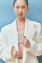 Model wears Dover emerald cut solitaire swept shoulder engagement ring in 18ct yellow gold