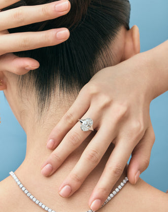 Model wears Bond 4ct oval solitaire semi-bezel engagement ring in platinum