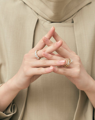 Model wears Marion emerald cut trilogy engagement ring in 18ct yellow gold