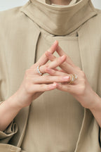 Model wears Marion emerald cut trilogy engagement ring in 18ct yellow gold