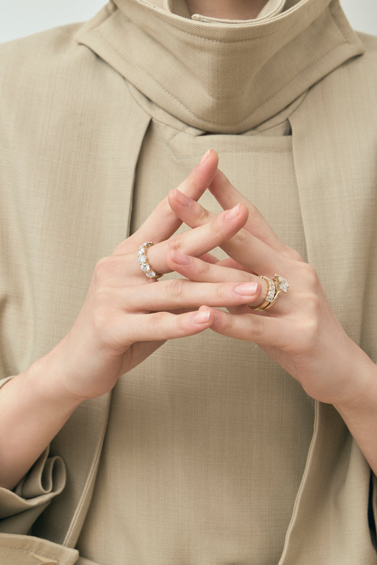 Model wears Marion emerald cut trilogy engagement ring in 18ct yellow gold