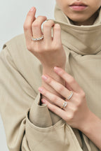 Model wears Marion emerald cut trilogy engagement ring in 18ct yellow gold