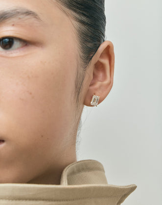 Model wears Clark 2ct emerald cut diamond studs in 18ct yellow gold